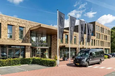 a van parked in front of a building with flags at Renaissance Amsterdam Schiphol Airport Hotel in Schiphol