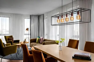 a living room with a table and chairs at Renaissance Amsterdam Schiphol Airport Hotel in Schiphol
