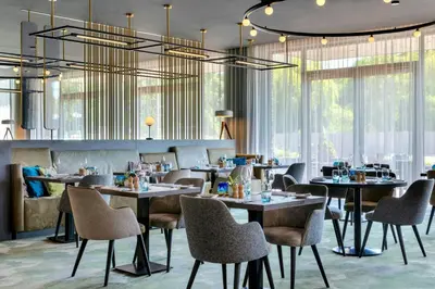 a restaurant with tables and chairs and windows at Renaissance Amsterdam Schiphol Airport Hotel in Schiphol