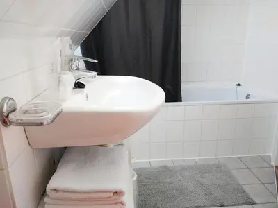 a bathroom with a sink and a bath tub at Appartementen Dorp & Duin in Egmond aan Zee