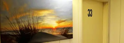 a painting of a sunset on the door of a room at Appartementen Dorp & Duin in Egmond aan Zee