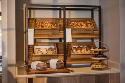 a display case filled with lots of different types of bread at Hilton Garden Inn Leiden in Leiden