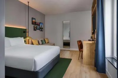 a bedroom with a bed and a living room at Hilton Garden Inn Leiden in Leiden