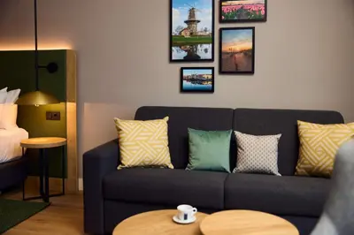 a living room with a couch and pictures on the wall at Hilton Garden Inn Leiden in Leiden
