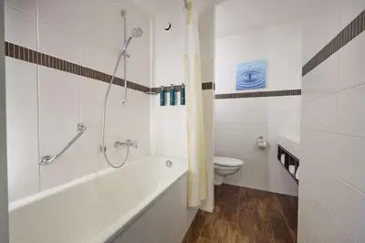 a white bathroom with a tub and a toilet at Hilton Garden Inn Leiden in Leiden