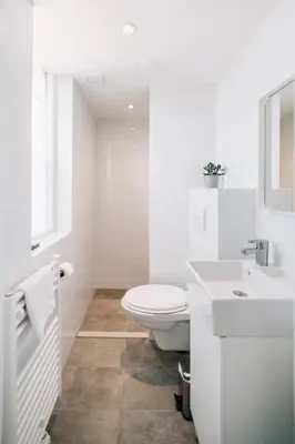 a white bathroom with a toilet and a sink at Zylt Zandvoort in Zandvoort