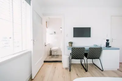 a white room with a table and two chairs at Zylt Zandvoort in Zandvoort