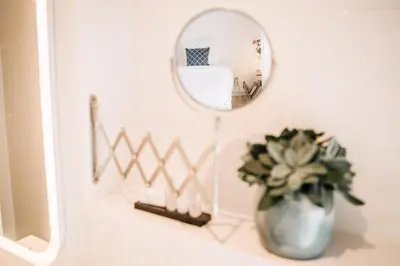 a bathroom with a mirror and a vase with a plant at Zylt Zandvoort in Zandvoort