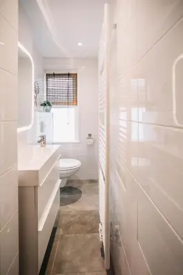 a white bathroom with a toilet and a sink at Zylt Zandvoort in Zandvoort