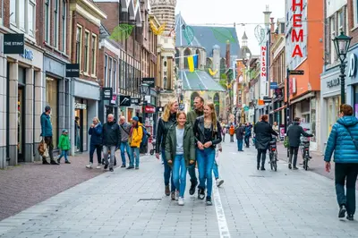 a group of people walking down a city street at Europarcs Koningshof in Schoorl