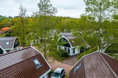 an aerial view of a house with trees and a car at Europarcs Koningshof in Schoorl