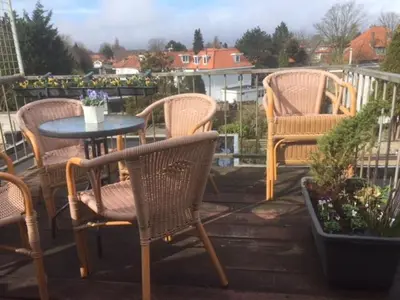 a group of chairs and a table on a patio at Gezellige zolder in Wassenaar met dakterras in Wassenaar