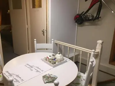 a white table and chairs with a white table and a room at Gezellige zolder in Wassenaar met dakterras in Wassenaar