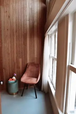a chair in a corner of a room with a window at Durty Nelly's Inn in Amsterdam