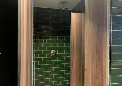a green tiled shower with a wooden door in a bathroom at Durty Nelly's Inn in Amsterdam
