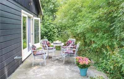 a patio with chairs and a table and flowers at Het Appelhuisje in Wijdenes
