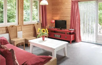 a living room with a couch and a tv and a table at Het Appelhuisje in Wijdenes