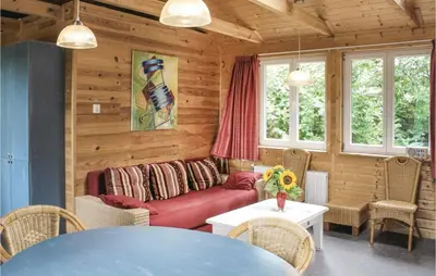 a living room with a red couch and a table at Het Appelhuisje in Wijdenes