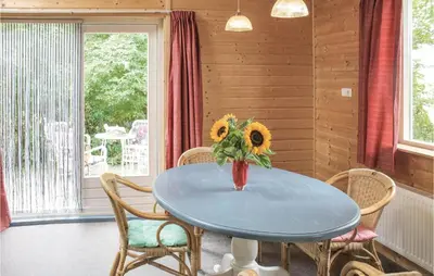 a blue table with chairs and a vase with sunflowers at Het Appelhuisje in Wijdenes