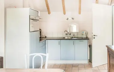 a kitchen with a sink and a refrigerator at Het Vissershuisje in Wijdenes