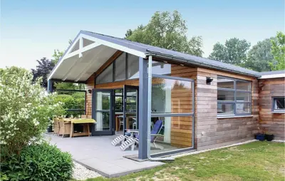 a house with a large glass door on a patio at Das Sommerhus 68 in Noordwijk aan Zee
