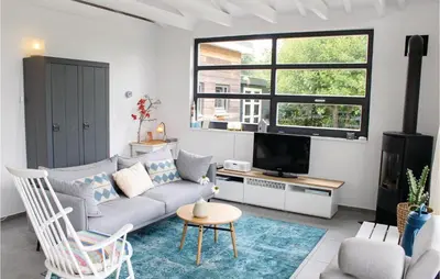 a living room with a couch and a tv at Das Sommerhus 68 in Noordwijk aan Zee