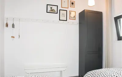 a bedroom with a black and white bed and a fireplace at Das Sommerhus 68 in Noordwijk aan Zee