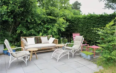 a patio with chairs and a couch and a table at Das Sommerhus 68 in Noordwijk aan Zee