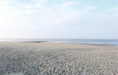 a beach with footprints in the sand and the ocean at Das Sommerhus 68 in Noordwijk aan Zee