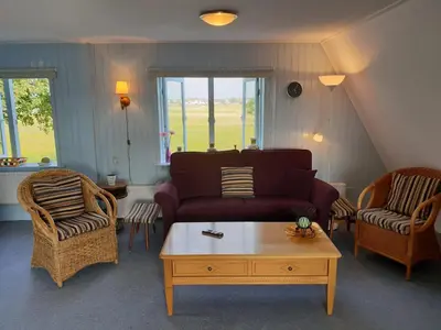 a living room with a couch and chairs and a table at Appartement Soigner! in Egmond-Binnen