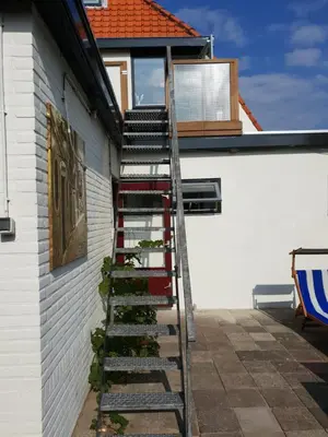 a ladder leading up to a house with a window at Appartement Soigner! in Egmond-Binnen