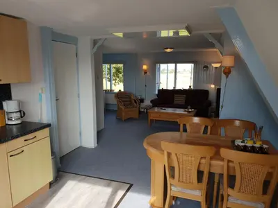 a kitchen and living room with a table and chairs at Appartement Soigner! in Egmond-Binnen