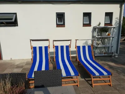 three blue and white chairs sitting on a patio at Appartement Soigner! in Egmond-Binnen