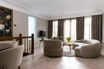 a living room with two chairs and a television at Amsterdam Canal Suites in Amsterdam