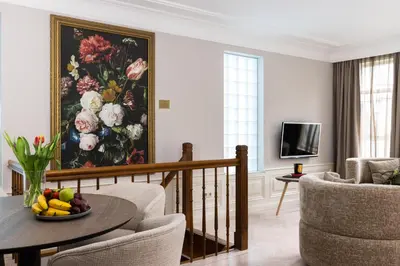 a living room with a painting of flowers on the wall at Amsterdam Canal Suites in Amsterdam