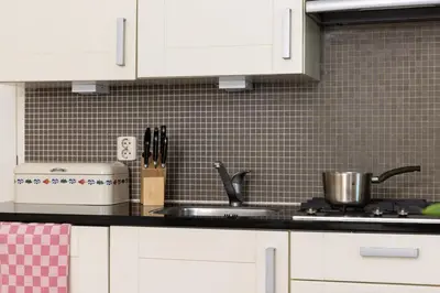 a kitchen with white cabinets and a sink at Amsterdam Canal Suites in Amsterdam