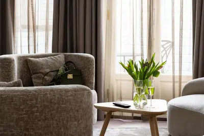 a living room with a chair and a laptop on a table at Amsterdam Canal Suites in Amsterdam