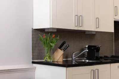 a kitchen counter with a vase with flowers in it at Amsterdam Canal Suites in Amsterdam