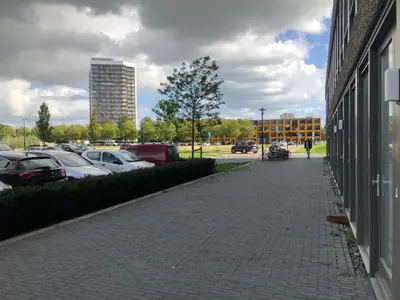 a brick sidewalk next to a parking lot with cars at Studio Amsterdam in Amsterdam