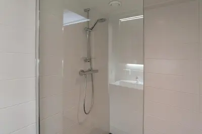 a bathroom with a shower with a glass door at Nassau Canal Suites - in the heart of the city in Amsterdam