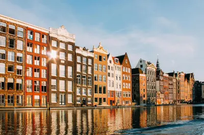 a row of buildings next to a river at Nassau Canal Suites - in the heart of the city in Amsterdam