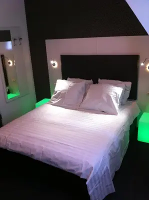 a bedroom with a large white bed with green lights at Hotel Vossius Vondelpark in Amsterdam