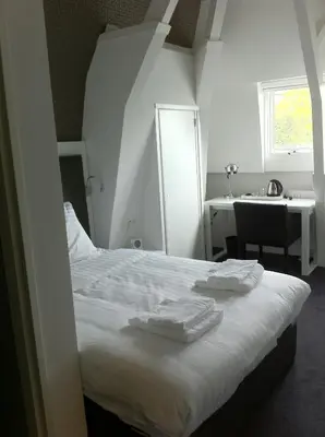 a bedroom with a bed with two towels on it at Hotel Vossius Vondelpark in Amsterdam