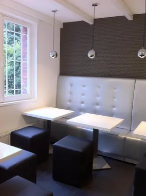 a dining room with two tables and stools at Hotel Vossius Vondelpark in Amsterdam