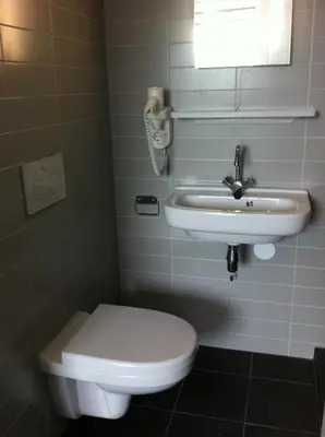 a bathroom with a toilet and a sink at Hotel Vossius Vondelpark in Amsterdam