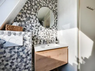 a bathroom with a sink and a mirror at Holiday Home Noordwijk near Beach & Sauna in Noordwijk
