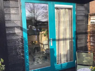 a blue door on a house with a window at Atelier Zonnehoek in Bergen