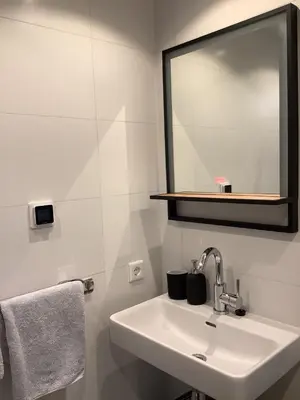 a white bathroom with a sink and a mirror at Atelier Zonnehoek in Bergen