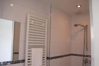a bathroom with a shower and a bath tub at Appartement De Zeester in Zandvoort