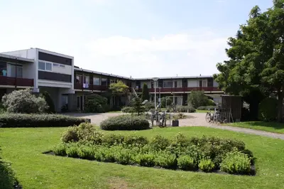 a building with bikes parked in front of a yard at Appartement De Zeester in Zandvoort